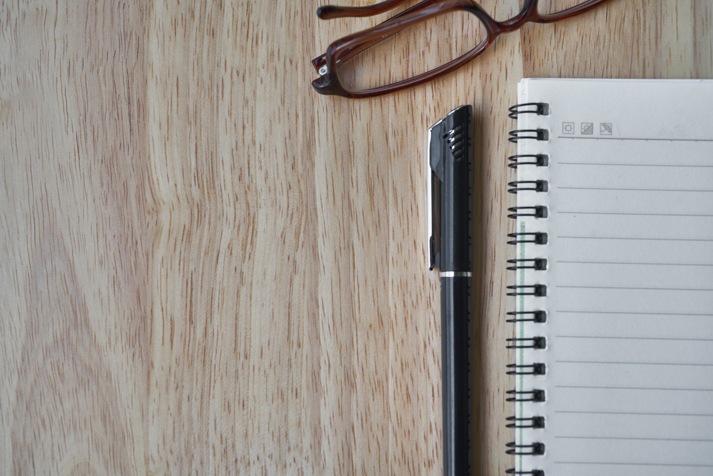 Notebook, Pen and Reading Glasses on Wooden Table